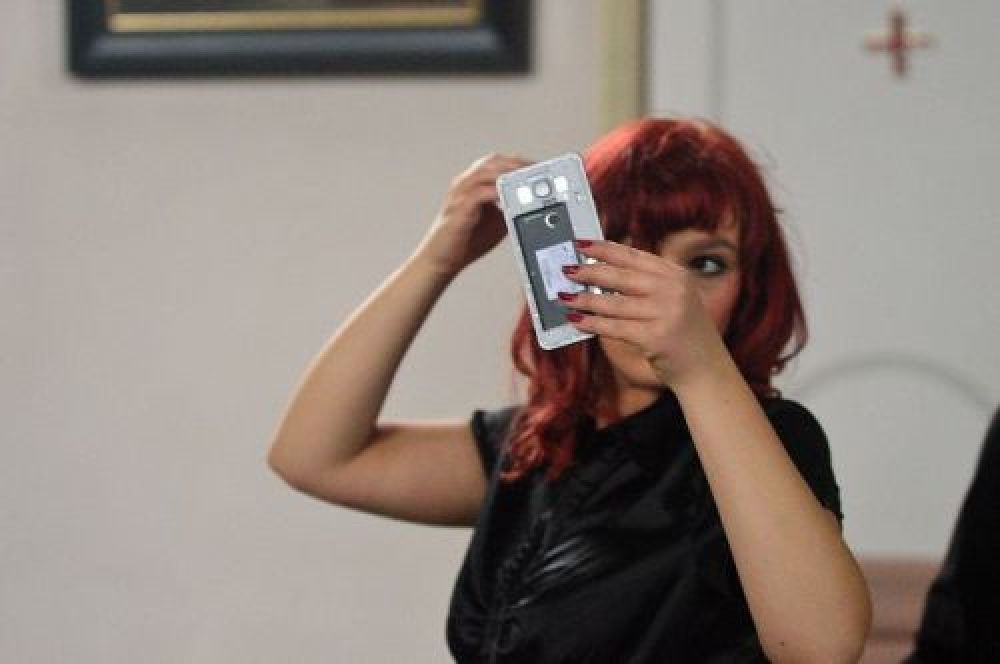 Frau fixt ihre Handy mit der Handykamera