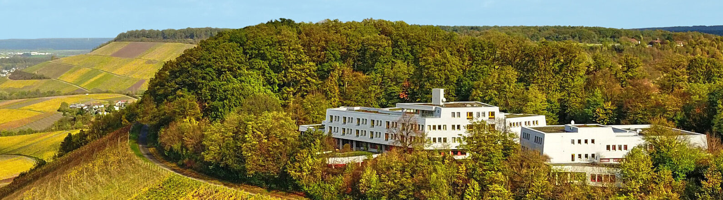 Drohnenaufnahme vom Bildungshaus das über Weinbergen thront mit Blick ins Tal